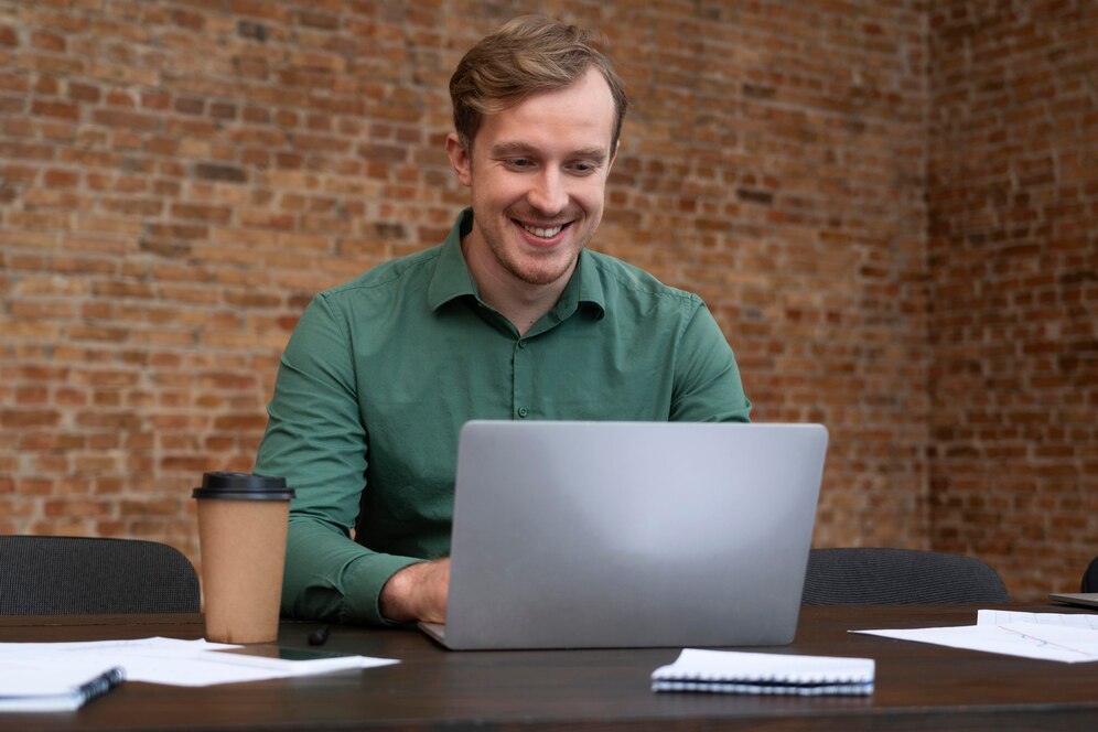 hombre de camiseta verde sostiene una sonrisa al probar un sistema de software en su computador de legalpin